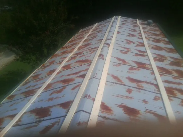 Rusted metal roof panels with new wood purlins before replacement — Storm Damage Roof Repair in Commerce City by Roofing Brothers